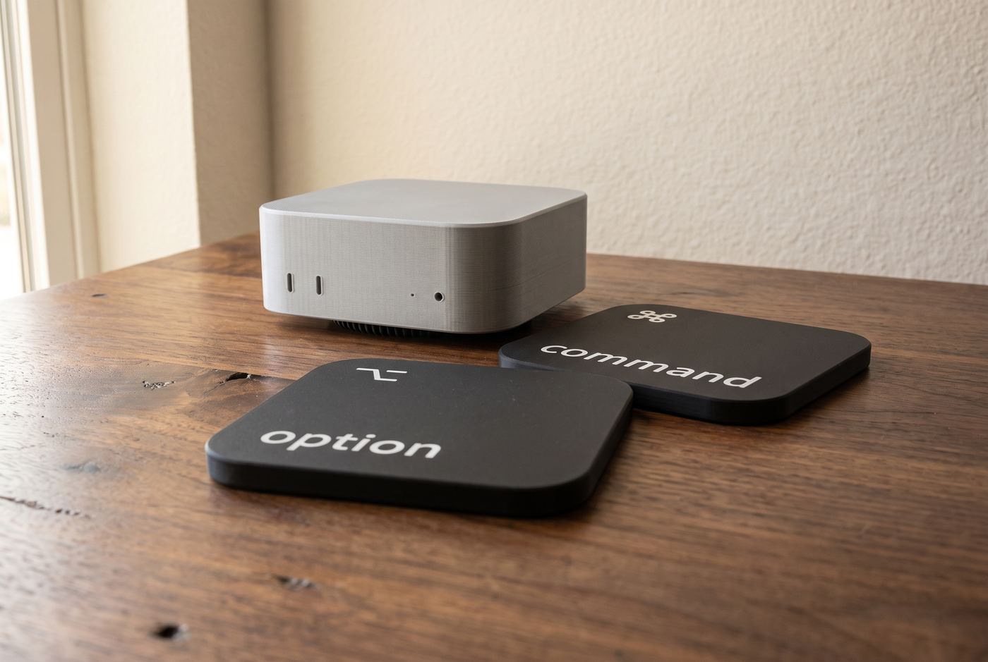 The holder with its cap on, and the command and option coasters lying on the desk in front of it.